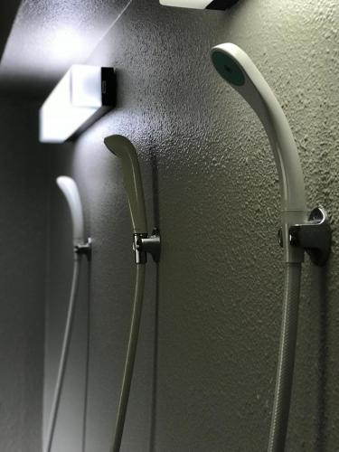 two handles on a wall in a bathroom at Fureai No Yado Yasuragi in Nozawa Onsen