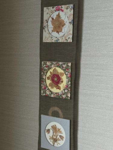 three pictures of plates on a wall with flowers at Fureai No Yado Yasuragi in Nozawa Onsen