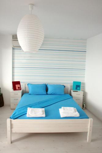 a bedroom with a blue bed and a large white lamp at Deep Blue Guest House in Sozopol