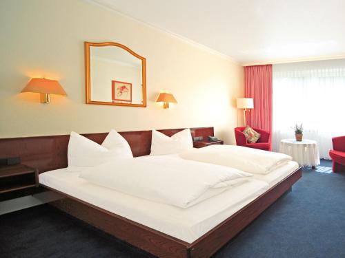 - un grand lit blanc dans une chambre d'hôtel dans l'établissement Hotel Maromme, à Norderstedt