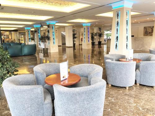 a lobby with chairs and tables in a building at Hotel Luxor in Playa de Palma