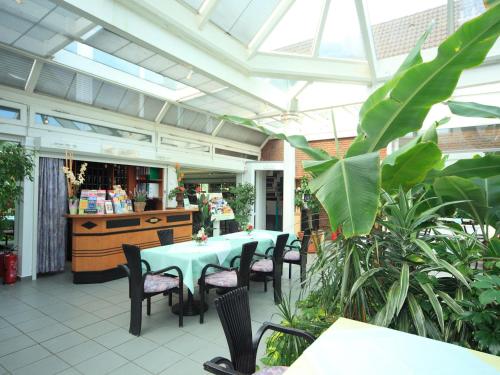 eine Terrasse mit einem Tisch und Stühlen in einem Gebäude in der Unterkunft Hotel Maromme in Norderstedt