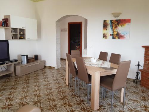a dining room with a wooden table and chairs at Villa Vera in Fontane Bianche