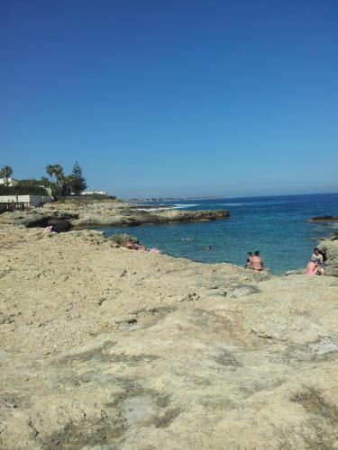 a group of people in the water at a beach at Villa Vera in Fontane Bianche