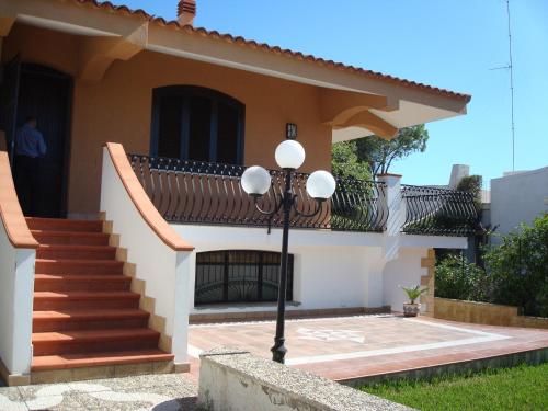 a house with a staircase in front of it at Villa Vera in Fontane Bianche