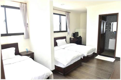 1 Schlafzimmer mit 2 Betten und einem Spiegel in der Unterkunft Lian-Yuan Homestay No. 1 in Insel Nangan