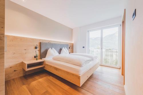 a bedroom with a bed and a large window at Sinnergut in Nalles