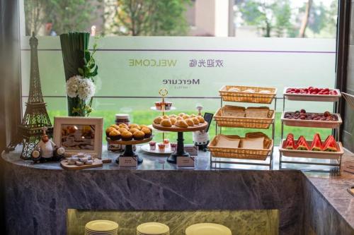 a display of food and desserts on a table at Mercure Shanghai Jiuting in Shang-hai