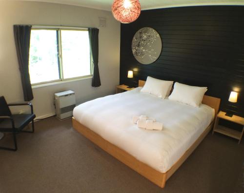 1 dormitorio con 1 cama grande con 2 velas en Annupuri Lodge at Niseko en Niseko
