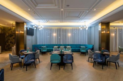 a restaurant with tables and chairs in a room at Mercure Shanghai Jiuting in Shang-hai