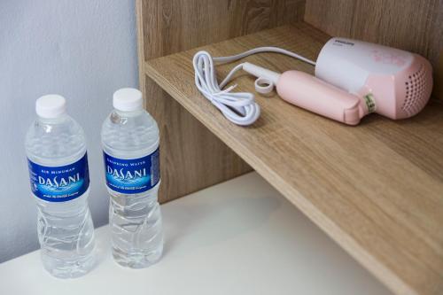 two bottles of water sitting on a wooden shelf at Hin Loi Guesthouse in Kota Kinabalu