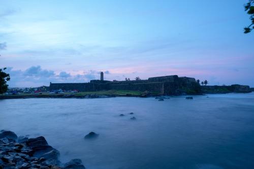 a large body of water with a factory in the background at Le Grand Galle in Galle