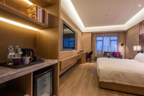 a hotel room with a bed and a desk at Mercure Shanghai Jiuting in Shang-hai