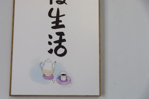 a picture of a sign with a kettle and a cup at Hin Loi Guesthouse in Kota Kinabalu