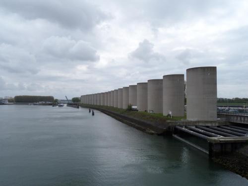 a row of silos on the side of a river at Hotel Rozenburg in Rozenburg