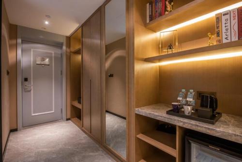 a room with a kitchen with a counter and a door at Mercure Shanghai Jiuting in Shang-hai