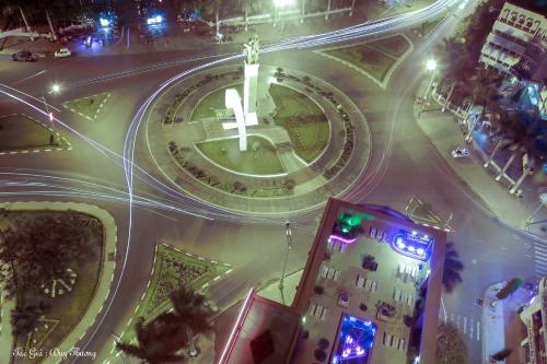 an intersection with a clock in the middle of a city at night at Sai Gon Ban Me Hotel in Buon Ma Thuot