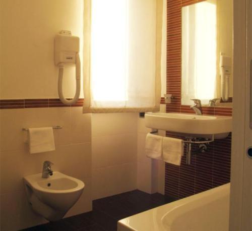 a bathroom with a sink and a toilet and a bath tub at Villa Nettuno in San Menaio