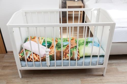 a white crib with giraffe pillows in it at Penzion Pohoda in Trutnov