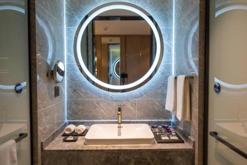 a bathroom with a sink and a mirror at Mercure Shanghai Jiuting in Shang-hai