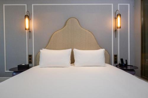 a bedroom with a large bed with two white pillows at Mercure Shanghai Jiuting in Shang-hai