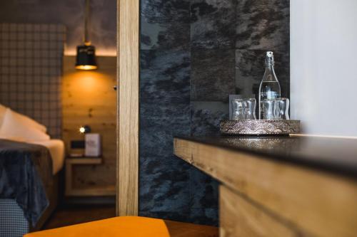 a hotel room with a bottle and glasses on a counter at DAS VIER Sport,- und Wellnesshotel in Sankt Leonhard im Pitztal