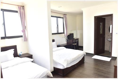 ein Hotelzimmer mit 2 Betten und einem Bad in der Unterkunft Lian-Yuan Homestay No. 1 in Insel Nangan