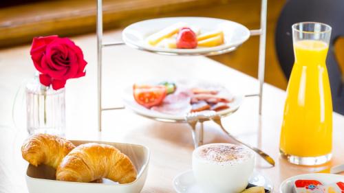 a table with a tray of croissants and a plate of food at Gasthaus Brünig Kulm in Brunig