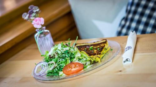 a plate of food with a salad and a sandwich at Gasthaus Brünig Kulm in Brunig