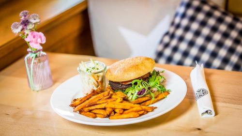 a plate with a hamburger and french fries on a table at Gasthaus Brünig Kulm in Brunig