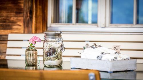 a glass jar and a vase with a flower on a table at Gasthaus Brünig Kulm in Brunig