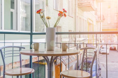 a table with a vase with flowers on a balcony at Апартаменты на Крещатике in Kyiv