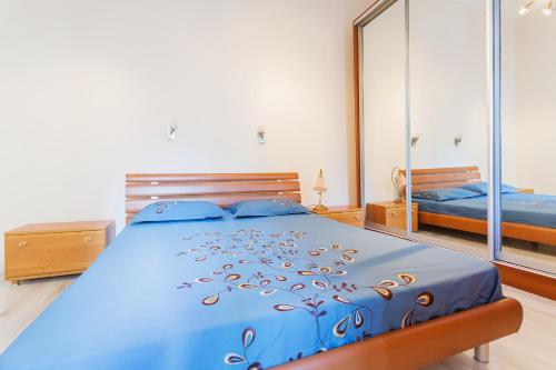 a bedroom with a blue bed and a mirror at Апартаменты на Крещатике in Kyiv