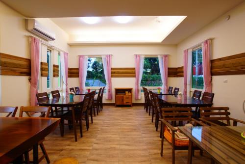 Jiji的住宿－嘟嘟鳥民宿 (全新電梯景觀民宿），用餐室设有桌椅和窗户。