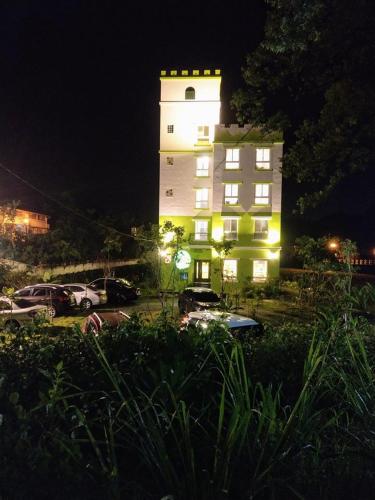 a tall building with a green light on it at night at DooDoo B&B in Jiji
