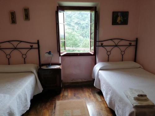Belmonte de MirandaにあるCasa Rural La Lleronaの窓付きの部屋 ベッド2台