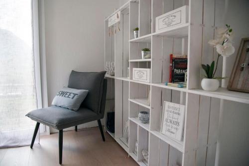 a chair sitting in front of a book shelf at Modern charme studio in Chalet in Ponto Valentino