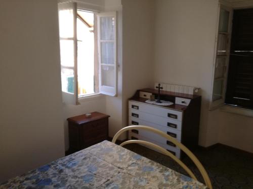 a bedroom with a bed and a dresser and a window at Appartamento nel centro storico di Sassello in Sassello
