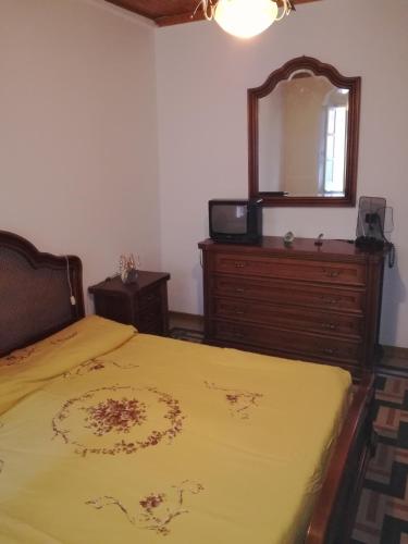 a bedroom with a bed and a dresser and a mirror at Appartamento nel centro storico di Sassello in Sassello