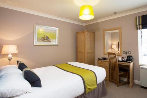 a bedroom with two beds and a desk and a mirror at Breckland Lodge in Attleborough