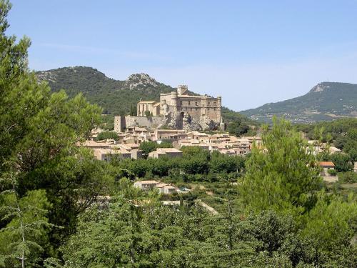 a town with a castle on a hill with trees at Lou Badabeu in Le Barroux