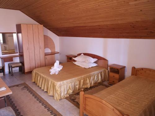 1 dormitorio con 2 camas y techo de madera en Pension Nina, en 23 August