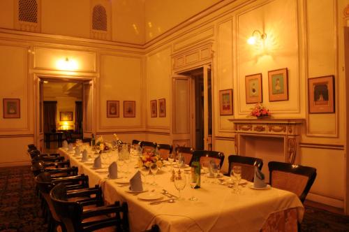 a long table in a room with tables and chairs at Palace Hotel - Bikaner House in Mount Ābu
