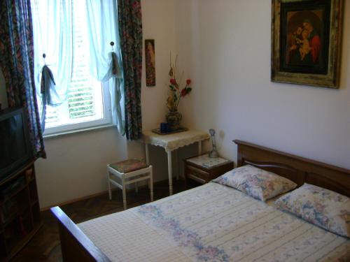 a small bedroom with a bed and a window at Guest House Marijana in Dubrovnik