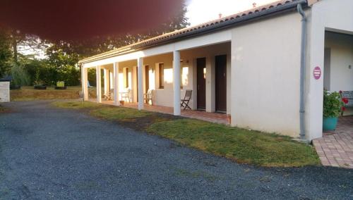 a white building with tables and chairs outside of it at Relais Motel de Maisonnay in Maisonnay