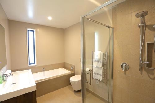 a bathroom with a shower and a toilet and a sink at Golden Sun Apartment -Two bedrooms, Three bedrooms in Christchurch