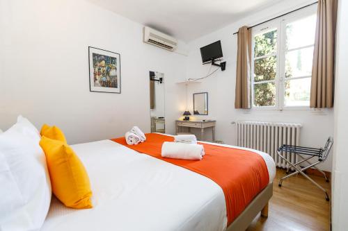 A bed or beds in a room at Hôtel Les Liserons de Mougins