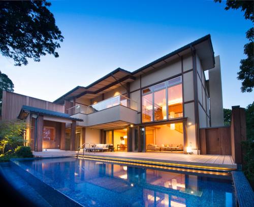 a large house with a swimming pool in front of it at ABBA Resorts Izu - Zagyosoh in Ito