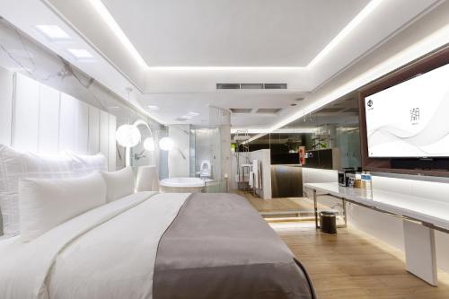 a bedroom with a large bed and a flat screen tv at Chao Motel in Taoyuan