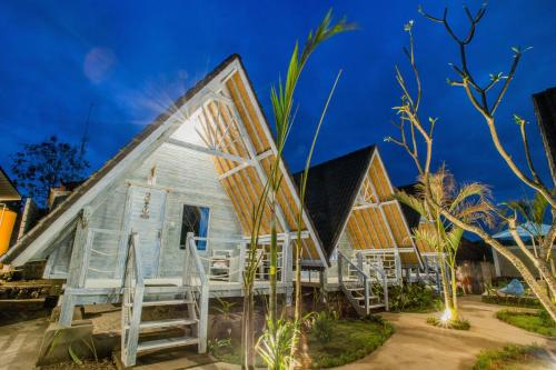 a small house with a gambrel roof at D'Yuki Huts Lembongan in Nusa Lembongan